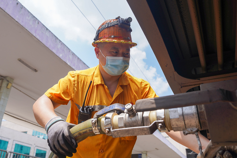 在超40度作業環境中，襄陽車站客運車間給水員周朝陽需要在20分鐘的站停時間內，為6-8節車廂上水吸污，通常一批次作業完畢后，身上早已經被汗水濕透。李樂詩攝