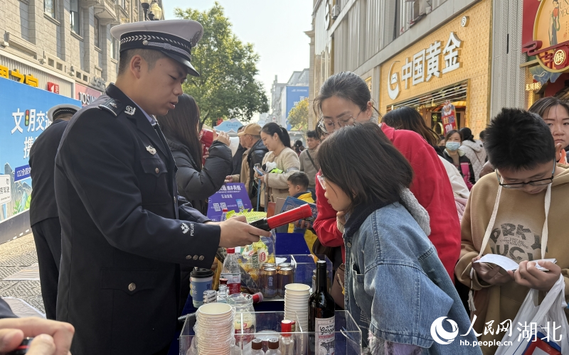 市民在拒絕酒駕體驗攤位對著酒精檢測儀吹氣。人民網(wǎng)記者 周恬